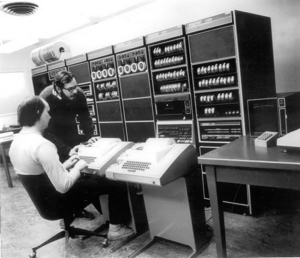 Ken Thompson ve Dennis Ritchie (ayakta) Bell Laboratuarında (1972). Kaynak: Computer History Museum